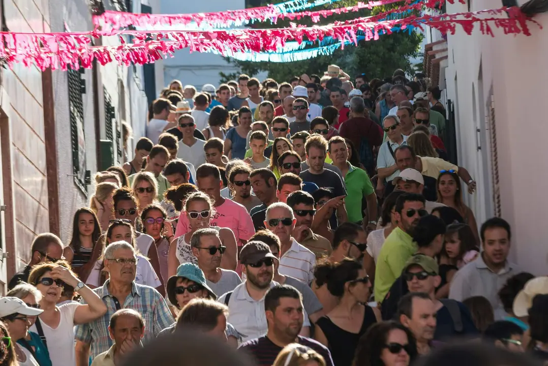 Ve&iuml;ns i visitants d&rsquo;Es Mercadal baixant pels carrers del poble durant les festes de Sant Mart&iacute;.
Foto: Jez Timms